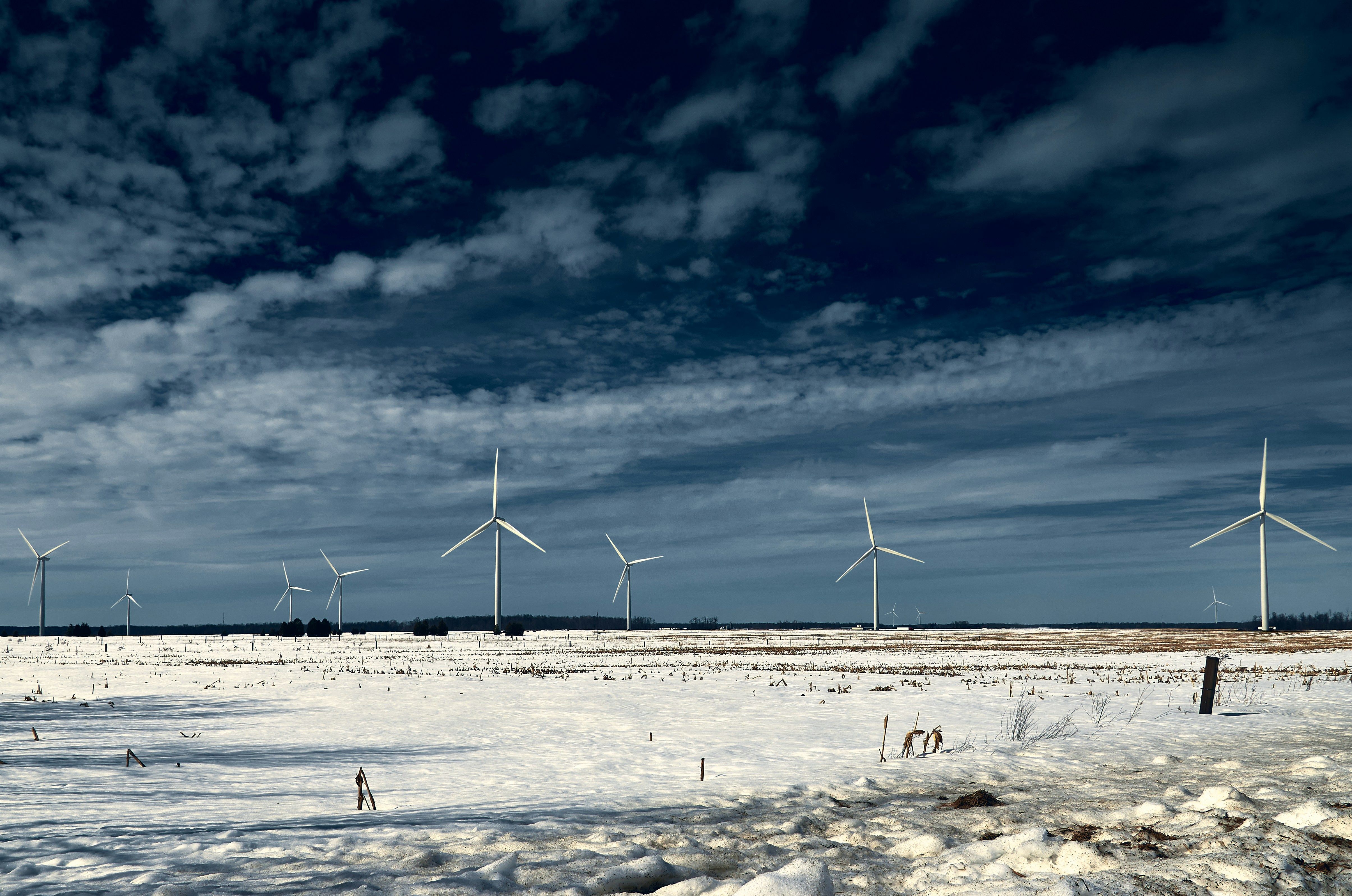 Beschneites Feld mit Windrädern im Hintergrund